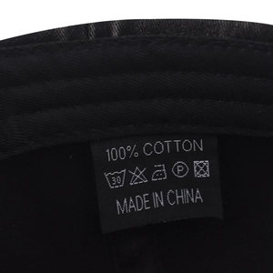 Macro detail of washing label showing 100% cotton material and care instructions