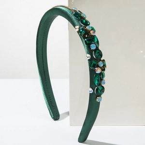 Detailed view of dark green satin headband with multi-shape emerald and blue crystals