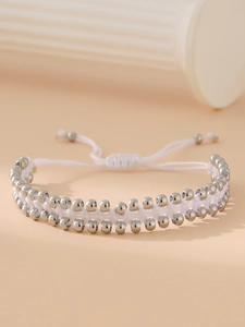 Détail d'un bracelet tissé fait main réglable avec des perles en acier poli argenté