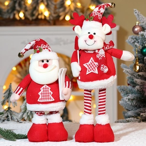 Detail of Christmas plush figurines featuring knitted sweaters and a wooden ski board accessory