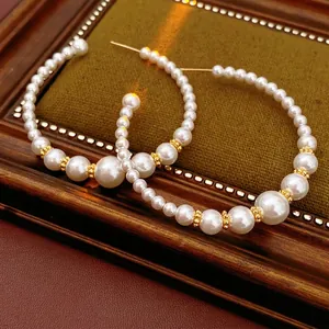 French vintage C-shaped hoop earrings with gradient pearls on a luxury velvet tray