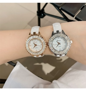 Detail showing two luxury quartz watches with rhinestone bezels and ceramic bands