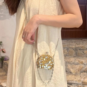 Detailansicht einer glitzernden Pailletten-Mini-Kettentasche, getragen von einem Modell.