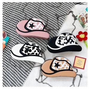 Flat lay view of four cowboy hat-shaped crossbody bags in assorted colors with star patterns