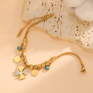 Gold plated bracelet with diamond clover charm, turquoise bead and round gold disc pendant