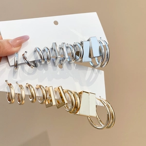 Close-up of gold and silver geometric C-shape earrings on display cards