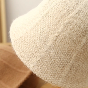 Close-up of soft beige plush knit bucket hat showing warm wool texture and stitching