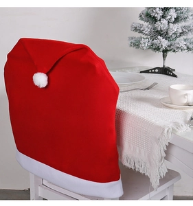 Macro detail of red velvet Christmas chair cover with white pompom and festive table decor