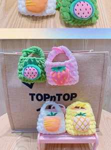 Detailed shot of handmade crochet fruit coin purses with colorful keychains and plush texture