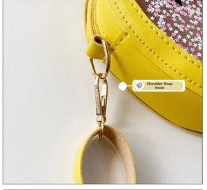 Detail of golden metal strap hook on yellow strawberry jelly bag with glitter stars