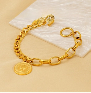 Close-up of golden stainless steel chunky chain bracelet with queen coin and OT clasp