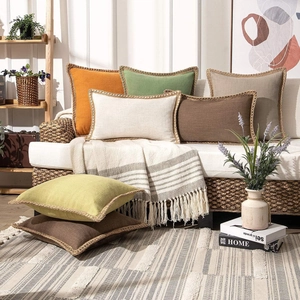 Linen decorative pillow covers in multiple colors on a stylish rattan sofa in a cozy room
