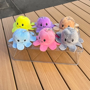 Reversible octopus plush keychains in six soft colors displayed on an acrylic stand