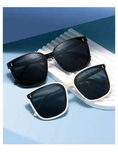 Detailed shot of square frame sunglasses with metal rivets on stylish wave base