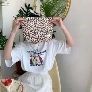 Détail d'une pochette vintage en velours côtelé à fleurs avec fermeture à glissière