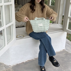 Detail of light green bubble texture handbag with LOVE SOZAKKA label held by model