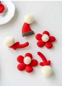 Set of red and white felt Christmas DIY accessories including flowers and Santa hats