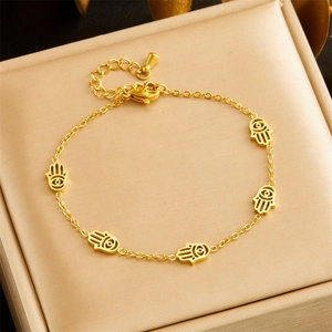 Elegant gold chain bracelet with five Hamsa Hand charms displayed in a beige jewelry box