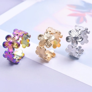 Detail of adjustable floral rings in colorful gold and silver finishes on a soft background
