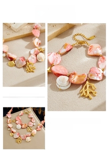 Detail of gold starfish and coral pendants with pink shell and pearl on chain necklace
