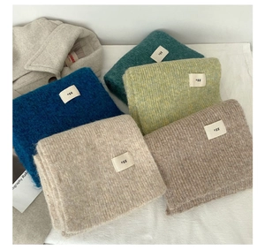 Detail of wool blend knitted scarves in multiple colors with egg label and soft texture
