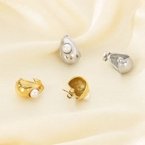 Detailed view of elegant pearl stud earrings with polished gold and silver metal bases