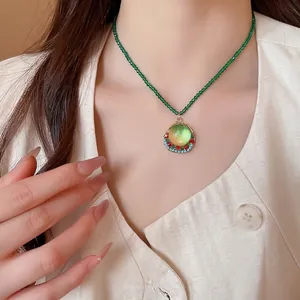 Vintage green crystal beaded necklace with gold geometric resin pendant on model