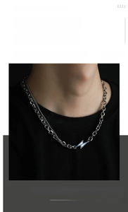 Macro shot of titanium steel cuban chain necklace with blue lightning bolt pendant