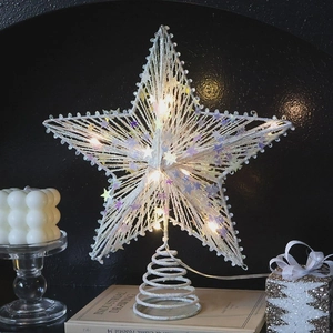 Champagne glitter Christmas star tree topper with warm LED lights on a vintage book