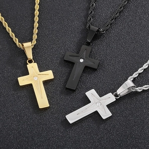 Detailed view of three stainless steel cross necklaces in gold, black, and silver finishes