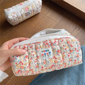 Detailed macro view of quilted floral cotton fabric with embroidery and white resin zipper