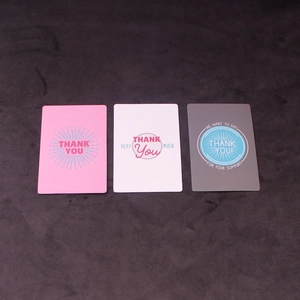 Close-up of pink, white, and gray greeting cards with elegant thank you messages