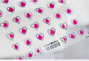 Macro detail of TS-692 5D embossed heart nail stickers with pink dots and barcodes