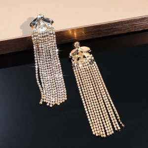 Macro shot of long gold tassel earrings with black and clear crystals for party wear