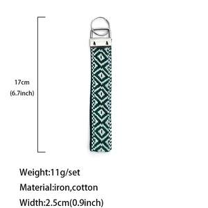 Handmade green and white woven keychain lanyard with geometric pattern and metal clasp