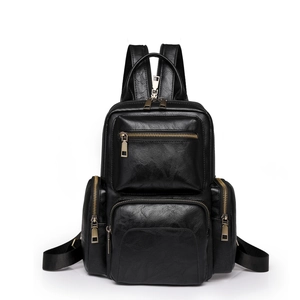 Close-up of matte black faux leather backpack with retro texture and multiple zip pockets