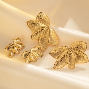 Gold leaf earring set with textured finish on champagne satin background