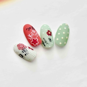 Adhesive nail stickers featuring hand-painted red floral and green dot designs