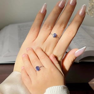 Close-up of mother and child wearing silver chain rings with oval blue zircon