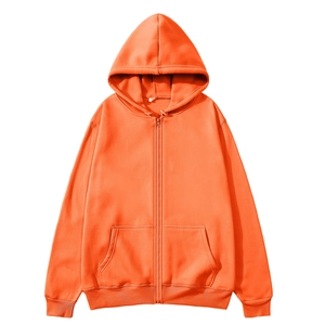 Detail of orange zip-up hoodie showing cotton texture, drawstring hood, and side pockets