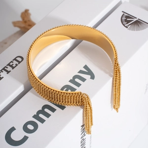 Détail d'un bracelet doré 18K avec tissage de perles délicates et ornements de longs glands