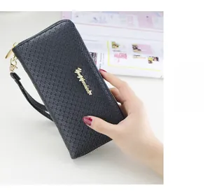 Detail of black cross-textured leather long wallet with gold wrist strap and metal logo