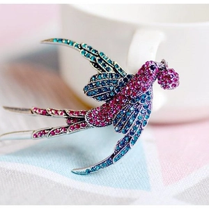 Spilla a forma di rondine con cristalli blu e rosa su base color argento