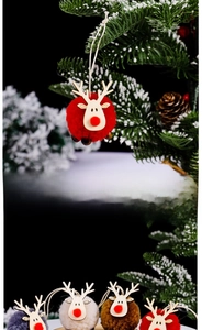 Detail of soft felt reindeer ornaments with plush balls and wood on snowy branches