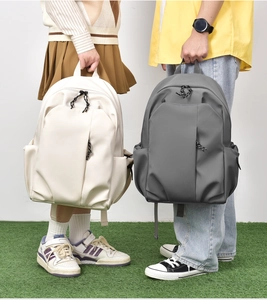 Detailed comparison of beige and grey minimalist nylon backpacks in outdoor campus setting