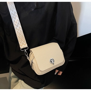 Close-up detail of the chic woven texture mini crossbody bag featuring a sleek metal lock.