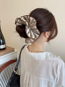 Close-up of large striped fabric scrunchie in coffee and beige on a bun hairstyle
