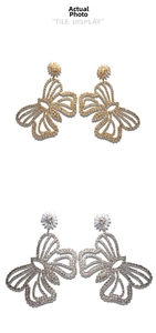 Detailed view of long dangling butterfly earrings with shiny rhinestones in gold and silver