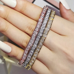 Close-up of three tennis bracelets featuring pink, white, and yellow square zircons