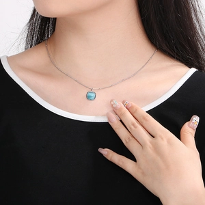 Detail of square sky blue cat eye stone pendant on a delicate silver stainless steel chain
